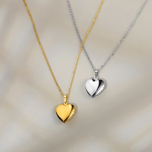 Golden and silver heart locket necklaces with high-polished finish on soft silk fabric