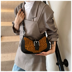Détail du sac léopard avec bandoulière en cuir noir et boucle en métal décorative