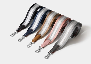 Close-up of colorful replacement handbag straps with silver stripes and metal buckles