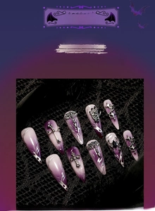 Dettaglio macro di unghie finte stiletto Halloween con sfumatura viola e ciondoli gotici