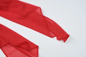 Detail of red mesh fabric showing fine texture and curled hemline stitching for short dress