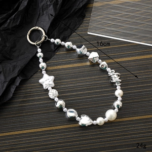 Silver beaded phone lanyard with pearls and star charms on a dark textured background