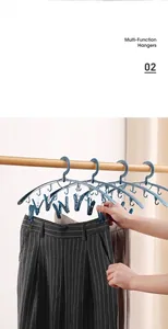 Blue non-deforming plastic hangers with multi-clip sock drying racks on a wooden bar