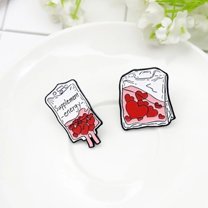 Supplied Energy blood bag enamel pin set with red hearts on a white ceramic plate
