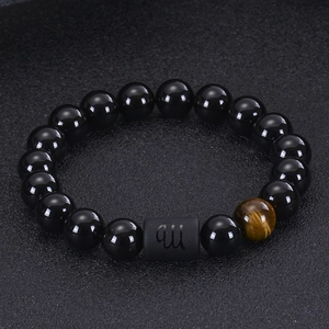 Detailed macro shot of black agate beads with tiger eye stone and Virgo zodiac symbol