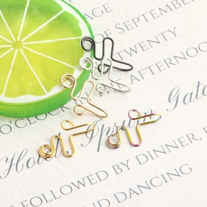 Close-up of five colorful U-shaped non-pierced stainless steel nose rings with lime