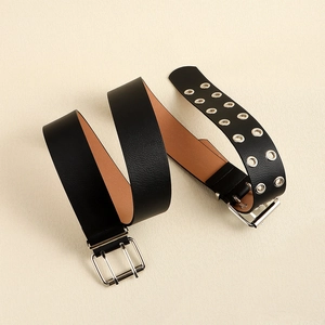 Detail of black leather punk belt featuring silver double-buckle and double-row holes