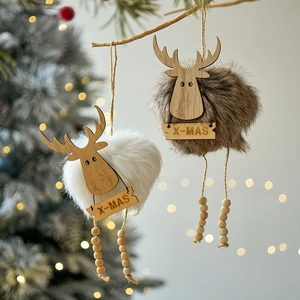 Plush Christmas reindeer ornaments with X-MAS wooden signs hanging on festive tree branches