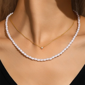 Close-up of layered S925 silver necklace with golden zircon pendant and white pearls