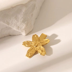 Vue détaillée d'une pince à cheveux fleur de cerisier dorée avec texture métallique