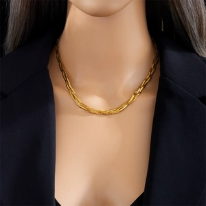 Close-up of a 18k gold braided rope chain necklace worn on a mannequin with a black blazer