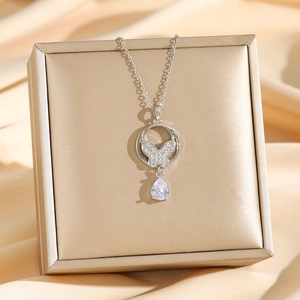 Collier argenté avec papillon pavé et goutte de cristal sur soie champagne de luxe