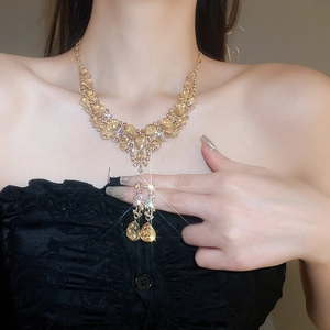 Close-up of a gold necklace and earring set with sparkling yellow teardrop crystals