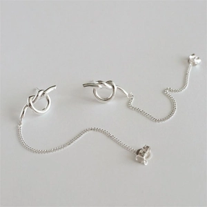 Detail shot of minimalist silver knot drop earrings with sleek long chain tassels