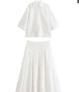 Vue détaillée de l'ensemble blanc chemise et jupe avec un tissu à texture plumes unique