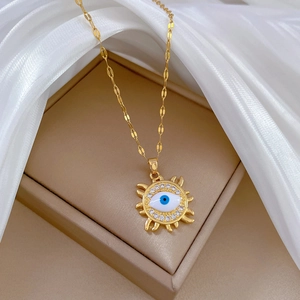 Elegant gold evil eye sun necklace with sparkling rhinestones on soft white silk