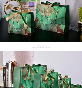 Detail of green marble gift bags with gold fluid texture and elegant ribbon handles