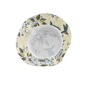 Detailed close-up of hummingbird and floral print on a light beige cotton bucket hat