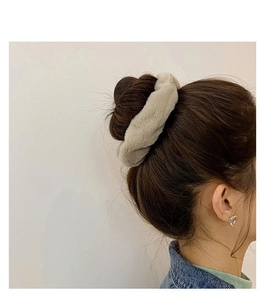 Close-up of soft beige faux rabbit fur scrunchie worn on a bun hairstyle