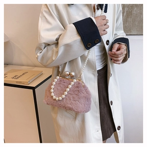 Pink faux fur handbag featuring pearl handles and elegant gold-tone pearl clasp detail