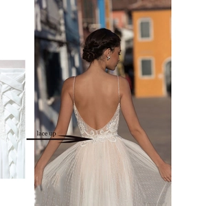Elegant white backless wedding dress with thin straps and lace-up back closure