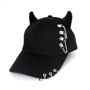 Detail of black baseball cap featuring devil horns and silver metal chain accents
