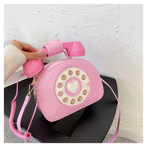 Detail of creative pink retro telephone handbag with rotary dial and handset strap
