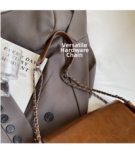 Detail of vintage brown tote featuring metal chain strap and woven faux leather texture