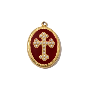 Detailed view of oval golden pendant with red enamel and white pearl cross inlay
