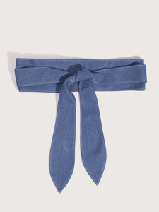 Detail of blue denim wide waist belt with adjustable bow knot and decorative stitching