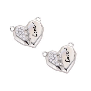 Detail of heart-shaped silver pendant with pearls, rhinestones and Love engraving