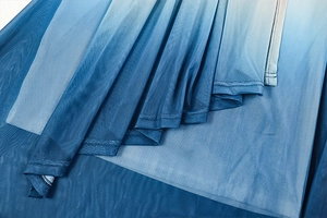 Close-up of blue gradient mesh fabric showing delicate pleated texture and soft netting