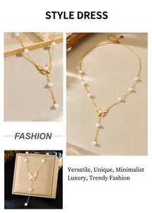 Detail of gold butterfly necklace with enamel wings, pearls, and long tassel chain