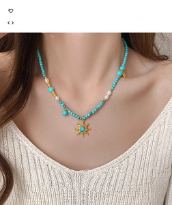 Vue détaillée du collier en perles et turquoise avec un pendentif soleil doré