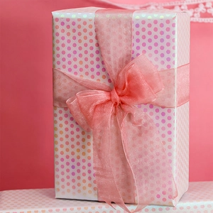 Pink polka dot gift wrapping paper with a matching organza bow for birthday presents