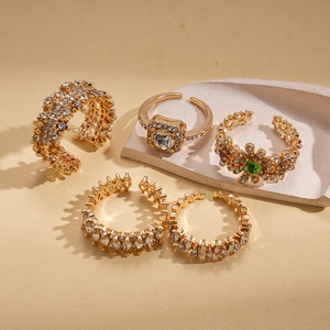 Macro shot of five-piece gold rhinestone ring set with olive green gemstone detail