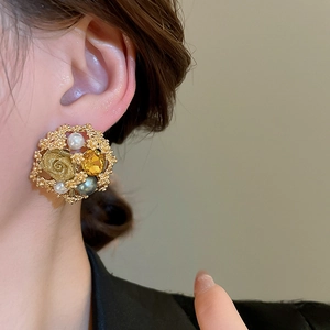 Detail shot of vintage flower earrings with pearls and amber stones on model