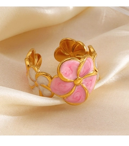 Detailed close-up of a pink and white enamel flower ring on elegant beige silk fabric