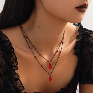 Detail of gothic teardrop pendants on a double-layer black chain necklace with red beads