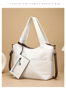Close-up of white pebble grain tote bag with brown straps and matching zipper pouch