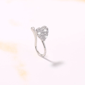 Close-up of a heart-shaped non-piercing nose ring with inlaid stones on marble