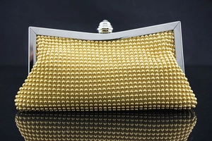 Nahaufnahme der goldenen Abendtasche mit Metallperlen und poliertem Silberrahmen