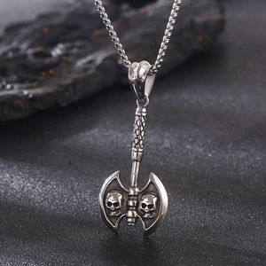 Macro view of stainless steel punk axe pendant featuring detailed dual skull engravings