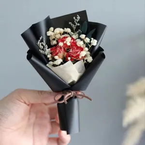 Detailed view of mini dried flower bouquet with red roses and baby's breath