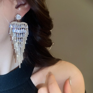Close-up of sparkling cubic zirconia tassel earrings worn by a model in silver finish
