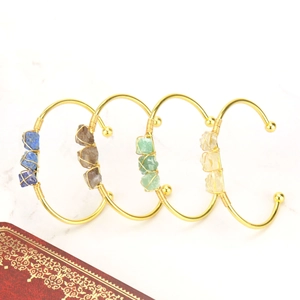 Detailed view of four handmade wire-wrapped cuffs with natural raw crystal gemstones