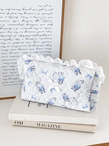 Quilted lace storage bag with blue cat pattern and ribbon bow in a lifestyle setting