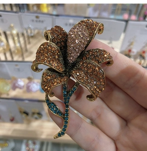 Macro detail of lily flower brooch with amber rhinestones and vintage gold plating