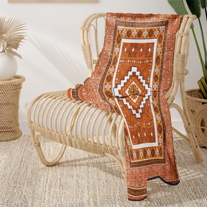 Detail of bohemian geometric pattern on soft orange and brown flannel throw blanket