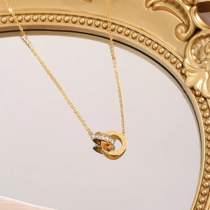 Collier double anneau doré avec chiffres romains et cristaux sur un miroir
